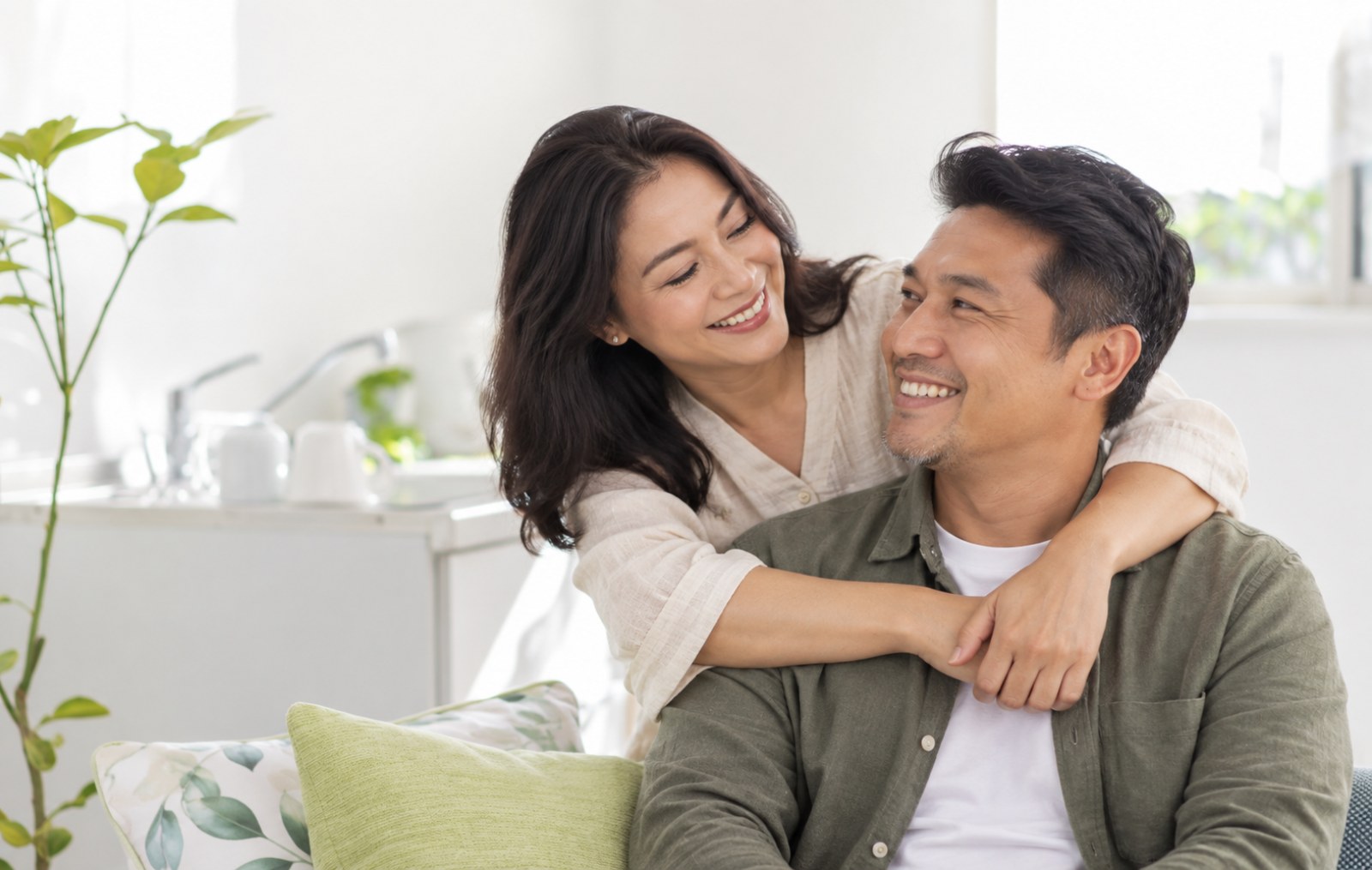 Couple at home, laughing together on the sofa